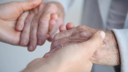 Grandmother And Granddaughter Holding Hands. Closeup.