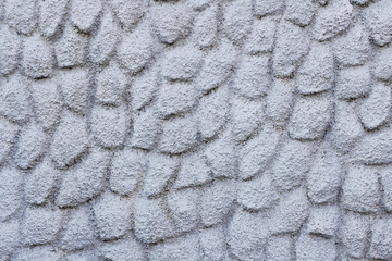 Old gray concrete wall background with rough texture and decorative stamp.