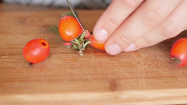 cutting, preparing, cleansing of wild rose, rosehip fruits for preserves