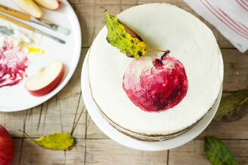 Apple cake with curd cream, decorated with painted apple on the background of autumn composition. Rustic style.