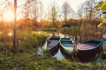 Obraz premium Sunset on the river in the fall with boats