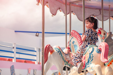 kids and Carousel . little girl is happy, enjoy playing the carousel horse During the weekend of...