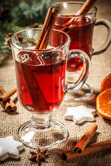 Glass of Christmas mulled wine with spices, orange and cookies on sackcloth