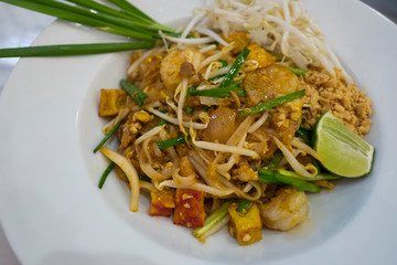 Top view of pad thai noodle in white plate.
