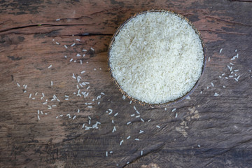 Wooden bowl with Organic parboiled rice on wood background. Top view, copy space, Healthy food.