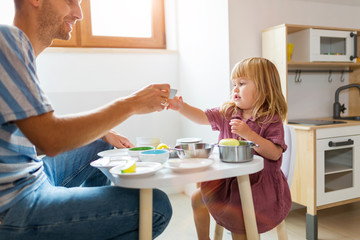 Father and daughter having a tea party at home
