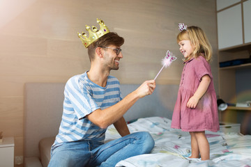 Father casting spell on daughter with magic wand
 - Powered by Adobe