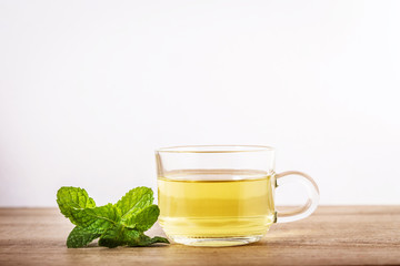 Close up a glass cup of mint tea with green fresh peppermint leaves , relaxation and healthy drink