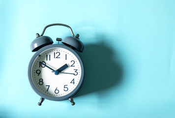 The Alarm clock on bright blue background , time management concept