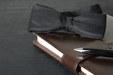 Bow tie, notebook and pen