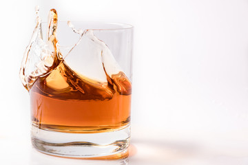 A shattering glass of brandy or brandy. Shards of glass and splashes of drink