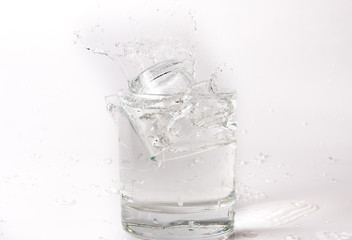 Falling and crashing glass of water. Shards of glass and splashing water