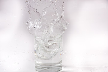 Falling and crashing glass of water. Shards of glass and splashing water