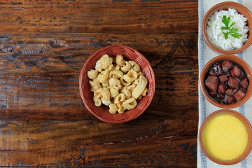 Brazilian feijoada, traditional dish of the Brazilian cuisine, on wooden table