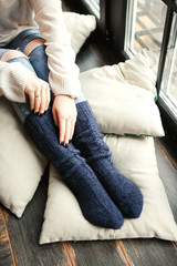 Feet girl in blue knitted socks. Cozy photo. Concept of lifestyle and winter holidays.