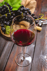 wine with branches of white grapes. On a wooden table.