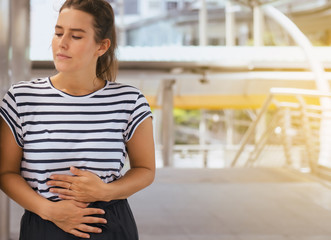 Woman having painful stomachache,Female suffering from abdominal pain outdoor