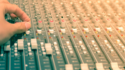 music mixer with hand adjust the knobs.