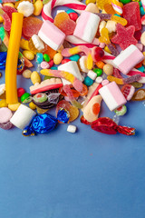 Colorful candies on table on blue background