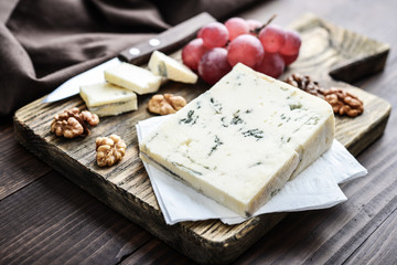 Slice of Gorgonzola cheese on cutting board