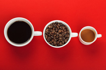 Coffee cup with coffee beans on red background.