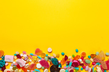 Fototapeta na wymiar colored candies on yellow background