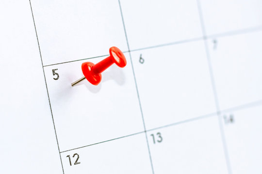 5 date on calendar with Red color pin. fifth day of month is marked with red thumbtack. Save the date.