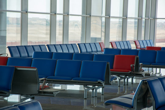 Empty seats in red-blue colors in the departure lounge at the airport