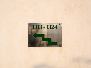 Nameplate with green stepped arrow pointing to the left with numbers