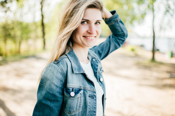 Beautiful long haired girl with postive emotional face outdoor art portrait. Cheerful smiling happy young woman at nature. Amazing stylish female with blue eyes posing outside. Laughing mood person.
