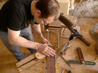 The process of making a cutaway on a classical guitar.