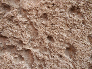 a rough brown pitted eroded limestone surface texture background