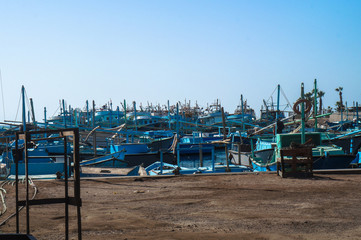 Fototapeta na wymiar Lots of blue various fishing boats, Fishermen?s vehicles in Egypt at the port of the fish market. Stock photos