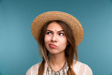 Portrait of a young pensive girl in summer hat