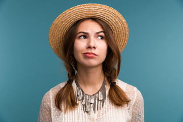 Portrait of a young pensive girl in summer hat