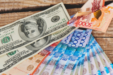 Dollars and tenge on a wooden background. Kazakhstan currency. Business and money..