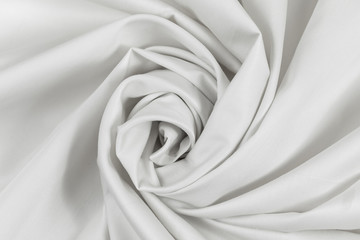 The monophonic fabric of white color showing a beautiful drapery a spiral.