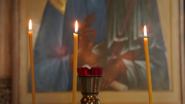 Lamp and burning candles in front of the icon in the Church