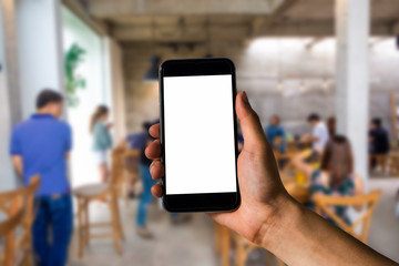Mockup image of hand holding white mobile phone with blank white screen in cafe.