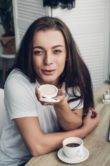 close-up portrait of smiling young transgender man blowing makeup blush at camera