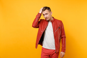 Portrait vogue confident handsome young man 25-30 years in red leather jacket, t-shirt stand isolated on bright trending yellow background. People sincere emotions lifestyle concept. Advertising area.