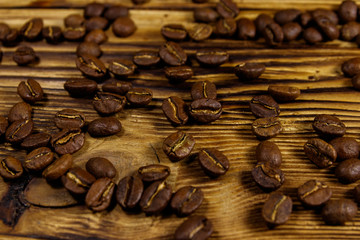 Roasted coffee beans scattered on rustic wooden table