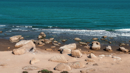 Fototapeta na wymiar Rocky sea coast with turquoise water on the beach