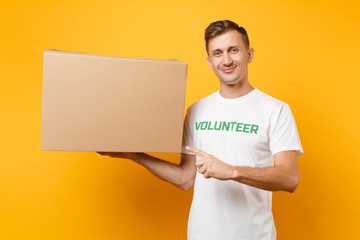 Portrait of good kind man in white t-shirt with written inscription green title volunteer with big...