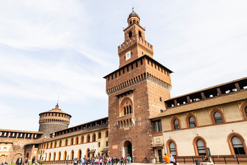 Traveler at front gate of Sforza Castle (Castello Sforzesco) is a castle in Milan, Italy