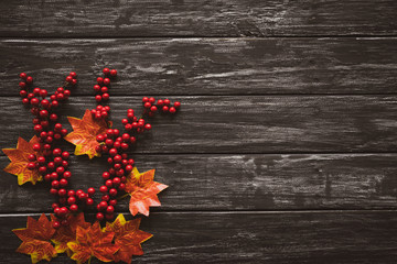 Top view of  Autumn maple leaves with red berries on old wooden backgound. Thanksgiving day concept.