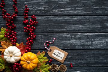 Top view of  Autumn maple leaves with Pumpkin and red berries on old wooden backgound. Thanksgiving day concept.