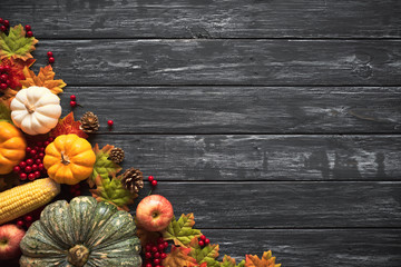 Top view of  Autumn maple leaves with Pumpkin and red berries on old wooden backgound. Thanksgiving...