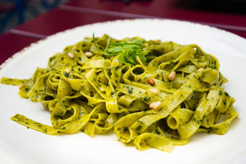 Pasta with pesto sauce and nuts on a the table