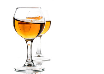 A round glass with brandy and a splash of drink inside